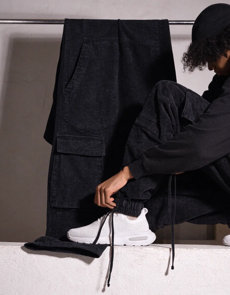 Jogger cargo negro colgado sobre una base de pared de yeso